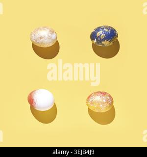 Four colorful dyed easter eggs on yellow background with shadows in bright artistic arrangement Stock Photo