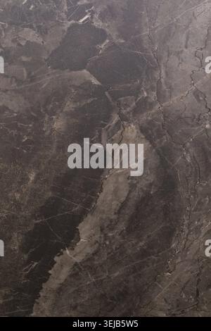 The natural stone features rich textures and earthy colors, displaying unique patterns and lines. This surface offers a sense of depth and visual inte Stock Photo