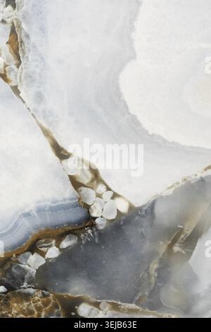 This close-up reveals the stunning details of a natural agate stone with swirling patterns of brown, white, and gray. The unique textures highlight th Stock Photo