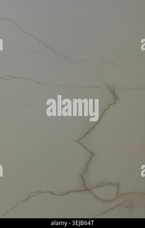 The cracked marble surface features unique veining patterns in light beige and cream colors, capturing the beauty of natural stone indoors. The textur Stock Photo