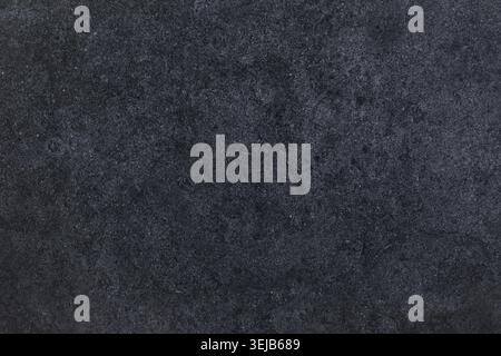 A smooth, dark textured surface displays a subtle, intricate pattern. This background creates a modern feel, perfect for various design applications o Stock Photo