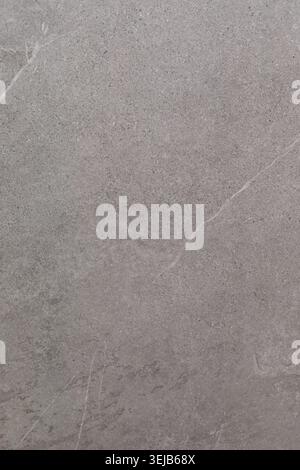 A smooth gray stone surface features subtle textures and lines. The natural light highlights the unique patterns, creating an elegant and simple appea Stock Photo