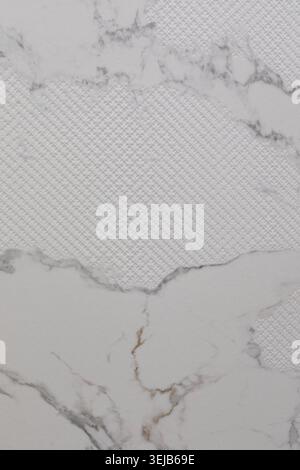 A close-up view of a textured white marble surface features a woven pattern that adds depth and interest. This surface can enhance modern interior des Stock Photo