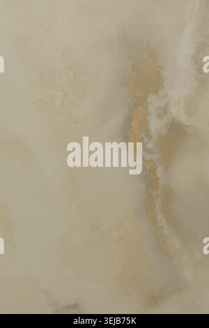 A smooth natural marble surface reveals soft beige and gold veins, creating a serene and elegant appearance. This stone texture highlights the beauty Stock Photo