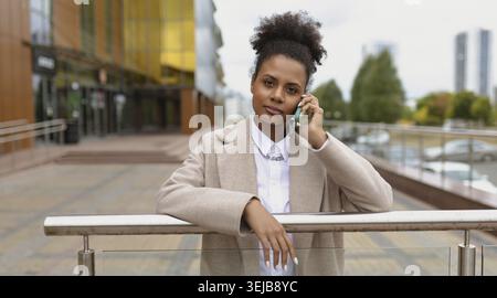 Serious young american woman lawyer talking on mobile phone Stock Photo
