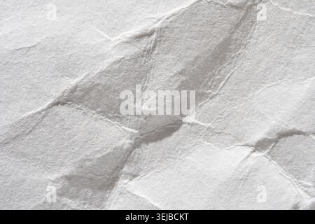 Close-up of textured white wrinkled paper surface with creased patterns Stock Photo