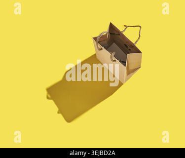 Open brown paper bag with shadow on bright yellow background minimalist composition Stock Photo