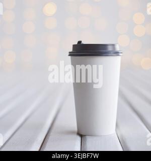 Minimalist white coffee cup on wooden surface with soft bokeh light background for simple and elegant design Stock Photo