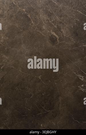 Dark brown marble features unique swirls and veins, showcasing its natural beauty. The smooth surface reflects light, highlighting the stone's elegant Stock Photo
