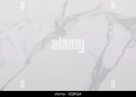 A smooth, elegant white marble surface displays graceful gray veining. This versatile material is perfect for countertops, flooring, and interior deco Stock Photo