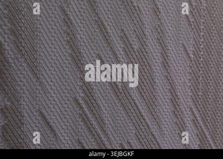 A textured wall surface features intricate patterns and subtle color variations, illuminated by natural light. The design creates an interesting visua Stock Photo