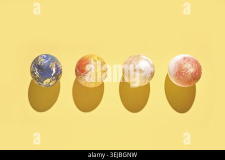 Colorful marbled balls on yellow background with shadows casting patterns Stock Photo