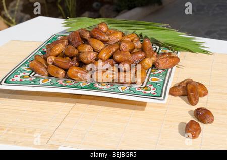 Ripe organic dates served on decorative ceramic plate. Stock Photo