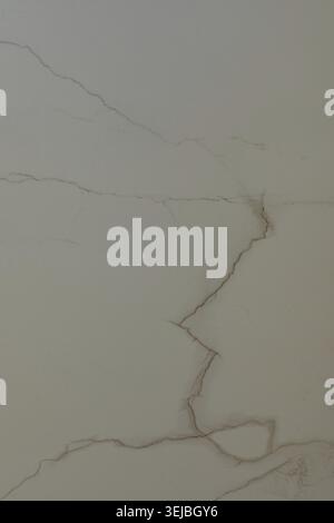 The cracked marble surface features unique veining patterns in light beige and cream colors, capturing the beauty of natural stone indoors. The textur Stock Photo