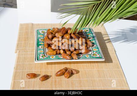 Ripe organic dates served on decorative ceramic plate. Stock Photo