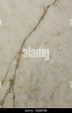 A close-up view of light beige marble displaying natural veins and textures. The surface's unique patterns make it suitable for various interior desig Stock Photo