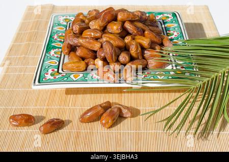 Ripe organic dates served on decorative ceramic plate. Stock Photo