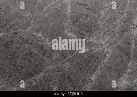 A smooth gray marble surface features intricate veins and patterns, showcasing the natural beauty and uniqueness of stone. The light reflects off the Stock Photo