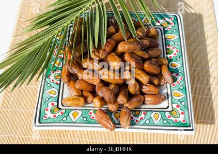 Ripe organic dates served on decorative ceramic plate. Stock Photo