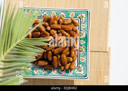 Ripe organic dates served on decorative ceramic plate. Stock Photo