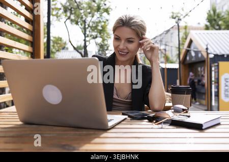 Young business woman working on laptop outdoors Stock Photo
