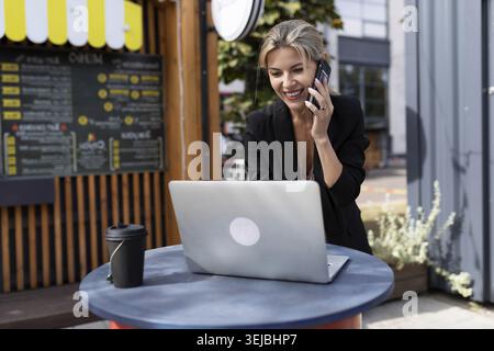 Young successful woman working on cafe laptop Stock Photo