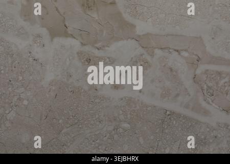 A close-up view of a natural stone wall reveals complex patterns formed by mineral veins. The surface blends soft colors and textures, creating a uniq Stock Photo