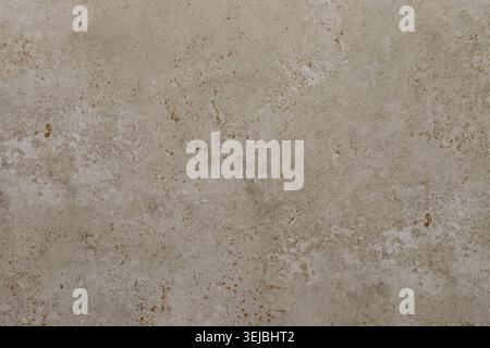 A detailed view of a textured beige concrete surface, showcasing natural patterns and slight imperfections that highlight its age and wear over time i Stock Photo