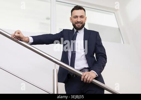 Presentable head man in a business suit on the stairs bottom view Stock Photo