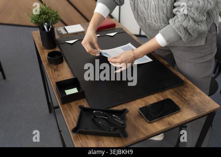 Woman businessman at her desk in the office folds a stack of documents Stock Photo