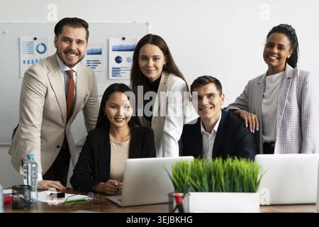 Team of young business people smiling looking at camera at workplace Stock Photo