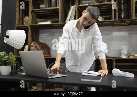 Elegant businesswoman working in the company behind a laptop Stock Photo