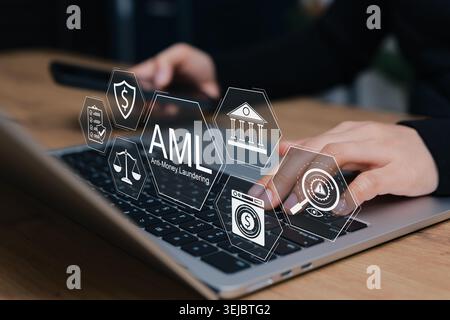 AML Anti-Money Laundering concept. business person typing on laptop interacting with digital icons of financial law, fraud protection, compliance, reg Stock Photo