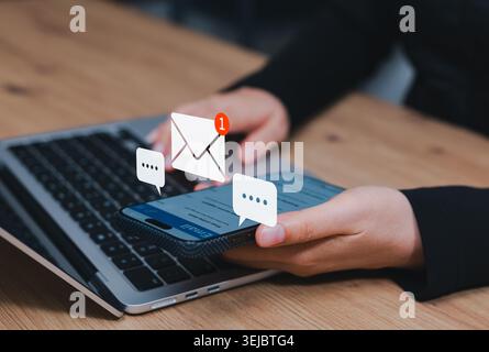 Email marketing and business communication concept. Person using smartphone showing virtual envelope notifications, speech bubbles. digital marketing Stock Photo