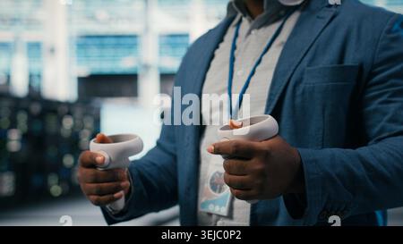 VR glasses equipment used by server hub employee to do maintenance tasks on machines. IT specialist in modern data center configuring settings with , camera B Stock Photo