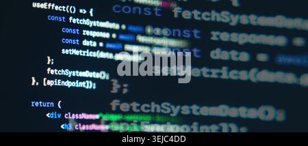 JavaScript React frontend code with fetch API syntax displayed on a dark monitor screen Stock Photo