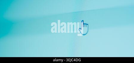 Macro photograph of a computer monitor displaying a hand pointer cursor on a light blue background with visible pixel grid Stock Photo