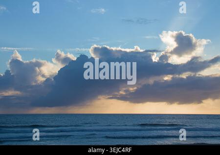 Majestic Sunset Over the Ocean with Dramatic Cloud Formations Stock Photo