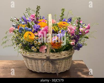 Colorful spring flower assortment in a wicker basket gift Stock Photo