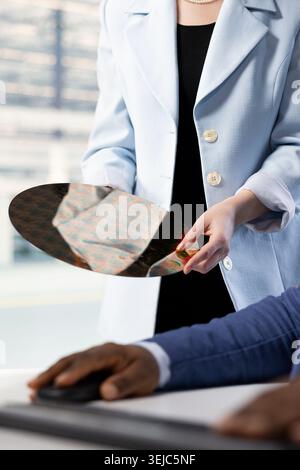 Doing quality inspection, silicon wafer close up and engineers in microchip factory RD lab. Examining intricate circuit patterns, semiconductor substrates and specialists Stock Photo