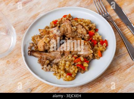 Traditional pearl barley porridge with stewed vegetables and fried rabbit on plate Stock Photo