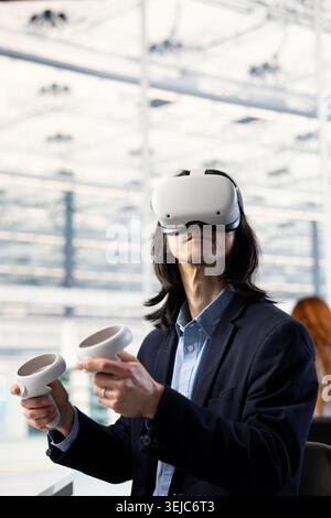 Evaluating PCB system architecture, VR goggles equipment and Asian man in RD office. Doing microelectronics design automation, EDA software and senior manager using virtual reality simulation Stock Photo