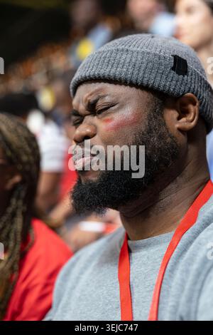 Close up of Black football fan closing eyes in disbelief during tense stadium match moment, gray beanie, face paint and emotional reaction. Devastating last minute loss, heartbreak. Stock Photo