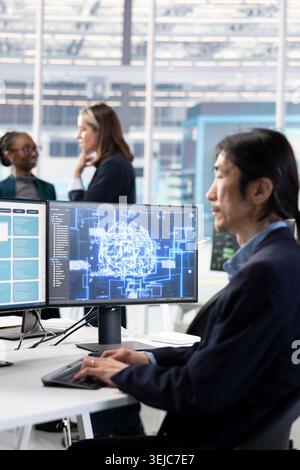 Training AI model, RD and Asian man in microchip factory RD office optimizing hardware. Using artificial intelligence, improving manufacturing efficiency and senior programmer in research lab Stock Photo
