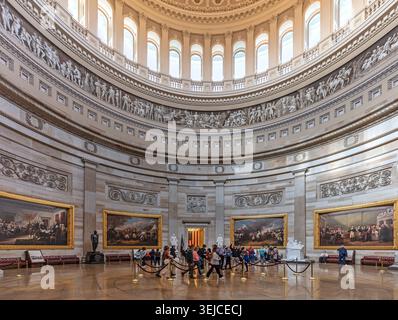 Tourists on guided tour inside US Capitol Rotunda beneath the dome with historic paintings, statues and Frieze of American History, Washington DC, USA Stock Photo