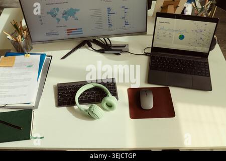 High angle view of analytics workstation displaying business dashboards on monitor and laptop, supporting data analysis and remote productivity. Ideal for business reporting or marketing Stock Photo