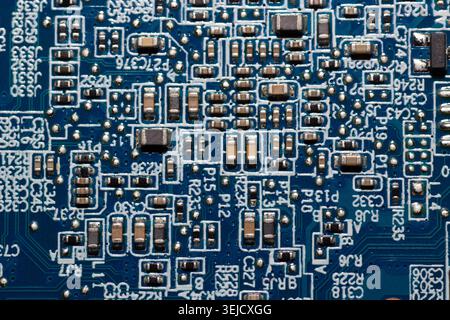 Macro photograph of a blue printed circuit board (PCB) with surface-mount components, resistors, capacitors, and solder joints. (132 characters) Stock Photo
