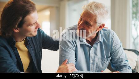 Support, home and senior father with man for conversation, connection and bonding together on weekend. Elderly dad, son or talking on sofa with parent Stock Photo