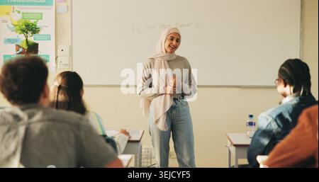 Teacher, students or woman with hijab in classroom, education or curriculum for knowledge development. Teaching, pupils or Muslim educator with Stock Photo