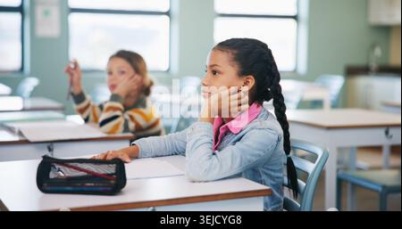 Child, learning and lesson in classroom, knowledge and listening to teacher for academic development. Elementary school, students and kids with Stock Photo